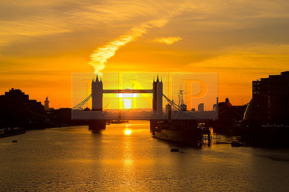 © Licensed to London News Pictures. 25/10/2015. London, UK. Sunrise behind Tower Bridge on the River Thames in London this morning. The skies are clear and the weather is much colder than yesterday in London for the first autumn morning after the clocks went back and UK time returns to Greenwich Mean Time (GMT) and officially marks the end of British Summer Time (BST).Photo credit : Vickie Flores/LNP