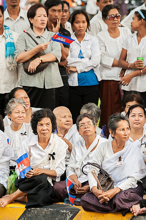 Mourners waiting for the body of former King Norodom Sihanouk to arrive in the Cambodian capital Phnom Penh following his death in exile at the age of 89 years. Grieving Cambodians wore white shirts with black ribbons, and flags flew at half-mast after the news of his death.