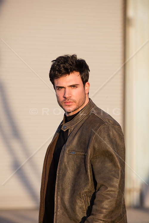 hot man in a leather jacket at sunset