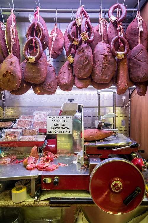 A selection of cured meats hang on display for sale in butcher shop at Istanbul Spice bazaar in Turkey