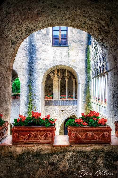 “Moorish style cloister and gardens in Villa Rufolo, Ravello”…<br />
<br />
The Villa Rufolo, which overlooks the Piazza Vescovado, is the historical and cultural center of Ravello. Built by a wealthy merchant family in the 13th century, the villa has a rich and storied past. Boccaccio, one of the earliest authors of the Italian renaissance, wrote a story about the villa and its owner in his Decameron. In its prime, it was one of the largest and most expensive villas on the Amalfi Coast, and legends grew about hidden treasure on its premises. When Sir Francis Neville Reid, a Scottish botanist, visited the villa in 1851, age and neglect had taken a toll on the villa and many of the rooms had fallen into ruin. Reid, however, fell in love with the Moorish towers and the expansive views. He purchased the villa and began an extensive renovation of the gardens and the remaining rooms. The town has become known as “la città della musica“, city of music, and for the past several decades the Villa Rufolo has been the center of an annual summer concert series that features piano concerts, chamber music, and a grand orchestral performance on a stage built jutting out over the Mediterranean Sea and the rugged Amalfi Coast below. The gardens and grounds of the Villa Rufolo are open year-round and attract visitors from all over the world. Juxtaposed against the sea, the sky, umbrella pines, and the Church of the Annunziata below, the gardens, with their profusion of flowers, have a magical quality to them. The villa itself contains two large towers and the larger of them stands next to a magnificent Moorish style cloister. Because of the magnificent gardens, the Moorish architecture, and the inspiring vistas, the Villa Rufolo is often described as a smaller version of Spain’s famed Alhambra. Traversing the Amalfi Coast was as thrilling as it sounds. The small towns built into the cliffside along the Mediterranean Sea romanticize of glorious past and envisage adventures to come.