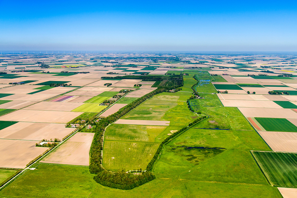 Nederland, Noordoostpolder, Schokland, 07-05-2018. Schokland, dorp en voormalig eiland in de Zuiderzee, gezien vanuit het Zuiden. Middelbuurt met hervormde kerk, onderdeel van het museum Schokland. Schokland maakt deel uit van de UNESCO Werelderfgoedlijst. Het verlagen van de grondwaterspiegel in de Noordoostpolder leidt tot inklinking waardoor het eiland steeds lager komt te liggen. Om verder wegzinken te voorkomen een hydrologische zone aangelegd. Village and former island, seen from the south. Part of the UNESCO World Heritage List. The center is the Reformed Church. Lowering the groundwater level in the Noordoostpolder leads to subsidence and causes the island the sink away. In order to prevent further decline a hydrological zone has been created. <br />
luchtfoto (toeslag op standard tarieven);<br />
aerial photo (additional fee required);<br />
copyright foto/photo Siebe Swart