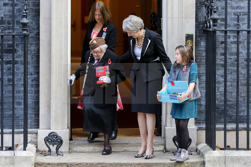 © Licensed to London News Pictures. 25/010/2018. London, UK. Prime Minister Theresa May meets fundraisers Barbara Windsor (93) and Poppy Railton (9) for the Royal British Legion and purchase a poppy to launch the National Poppy Appeal 2018 outside 10 Downing Street. Photo credit: Dinendra Haria/LNP