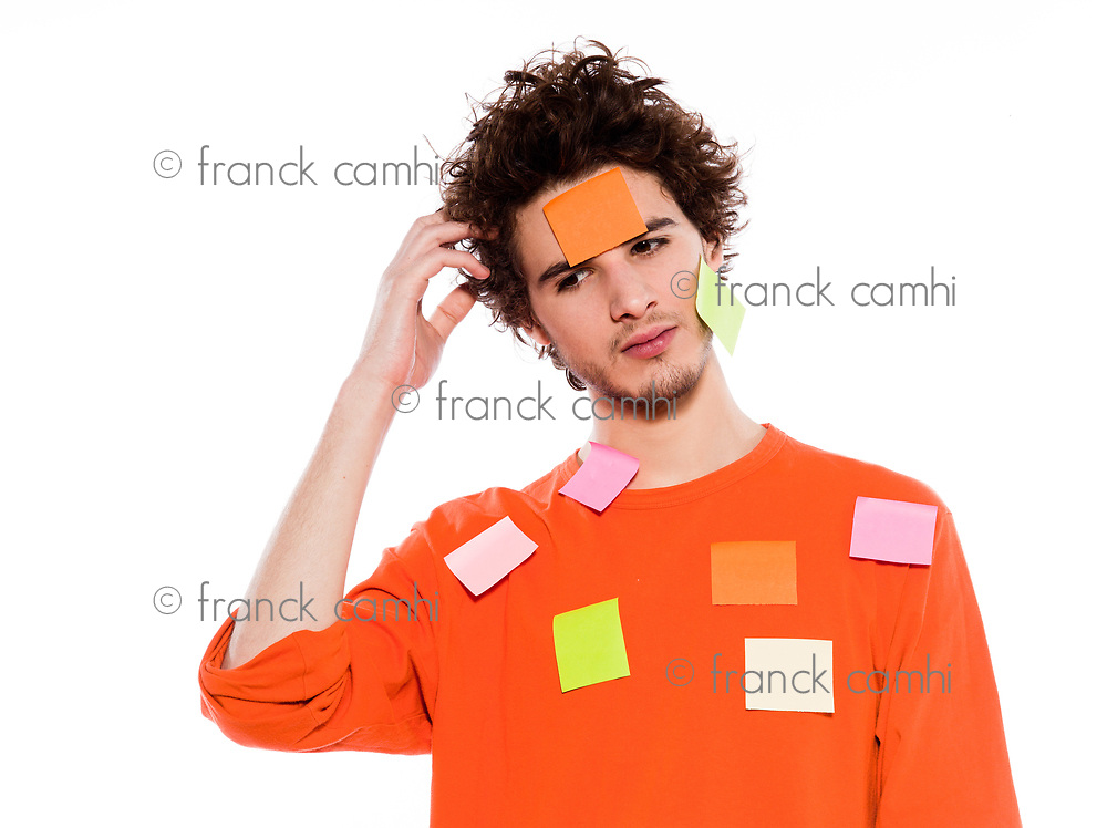 one young thinking with adhesive notes covering caucasian man portrait in studio on isolated white background