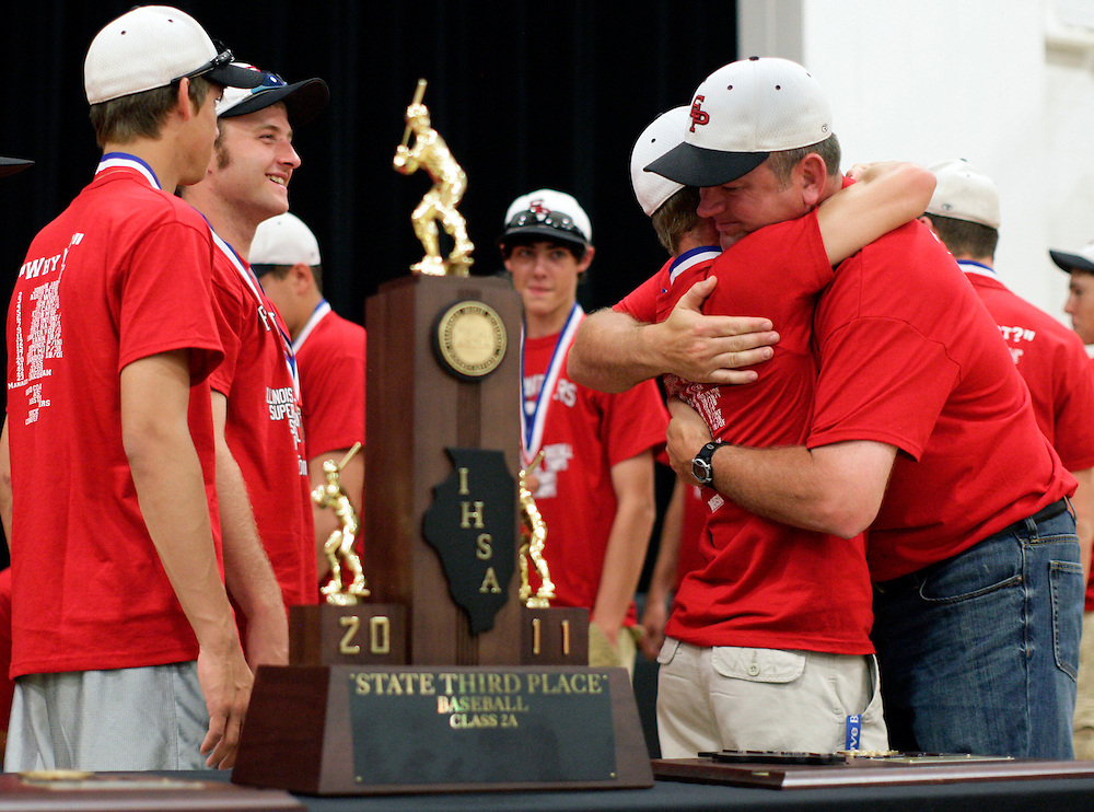 (20110605, Prophetstown, Illinois)..Erie-Prophetstown head coach Jason Orman, right, hugs players at an event on Sunday, June 5, 2011 at the Prophetstown High School gymnasium to celebrate the team's 3rd place finish in the Illinois State Class 2A baseball championships...Moline Dispatch, Brooks Canaday.