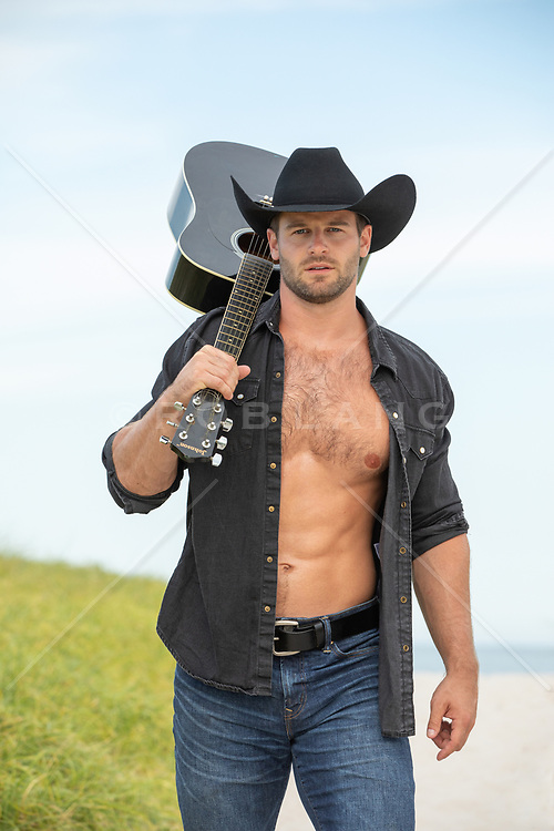 hot cowboy with open shirt holding a guitar