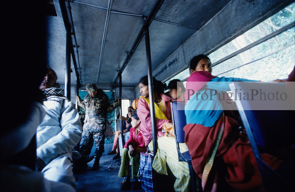 Kathmandu Valley, 12 February, 2005. Military check point on the outskirt of Kathmandu. All the men get off the bus and walk through the checkpoint, women and foreigners are allowed to stay in the bus. A soldier checks the luggages on board.