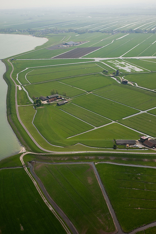 Nederland, Noord-Holland, Gemeente Zeevang, 28-04-2010; Polder de OosterKoog, buitendijks land van de Zuiderzee, in de voorgrond. Op het tweede plan Polder de Etersheimerbraak. Deze laatste polder is een voormalige 'braak' (dijkdoorbraak) die in 1632 bedijkt is (en vervolgens drooggemaakt). Tijdens de watersnood van 1916 stond het water aan de kruin van de Zeevangszeedijk (Zuiderzee- of IJsselmeerdijk). Om de dijk op te hogen - met klei, zijn in 1917 in de Etersheimerbraakpolder kleiputten gegraven (het gedeelte tussen de boerderijen)..Foreground polder outside the seawall, behind it the Polder Etersheimerbraak. This polder is a former 'breach' (levee failure) that was diked in 1632 (and subsequently dried). During the flood of 1916, the water stood at the top of the Zeevang seawall. To raise the top of the seawall, clay was needed and in 1917 clay pits were dug in the Etersheimerbraakpolder (the part between the farms)..luchtfoto (toeslag), aerial photo (additional fee required).foto/photo Siebe Swart