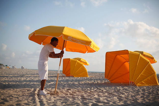 4/3/13---Miami Beach, Florida---Photo by Angel Valentin<br />
Julio Pagan, a beach attendant for Westgate Resorts, sets up beach umbrellas, cabanas and chairs on the sands of Miami Beach near 36 street in the early hours of the morning.