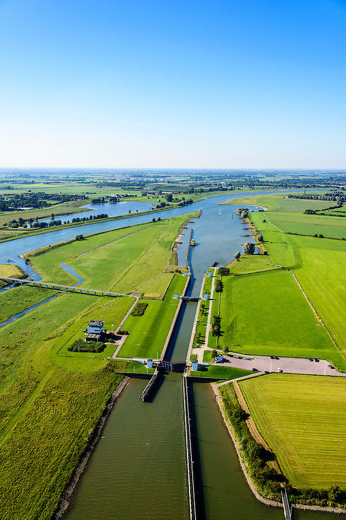 Nederland, Gelderland, Gemeente Overbetuwe, 30-09-2015; stuwcomplex bij Driel in de Neder-rijn. De stuw reguleert waterniveau in de Neder-rijn en de IJssel. Bijgenaamd De Kraan van Nederland. Naast de stuw een schutsluis voor de scheepvaart en de vispassage.<br />
Barrage (weir) or flood gate in Lower Rhine, regulates waterlevel, west of Arnhem.<br />
luchtfoto (toeslag op standard tarieven);<br />
aerial photo (additional fee required);<br />
copyright foto/photo Siebe Swart