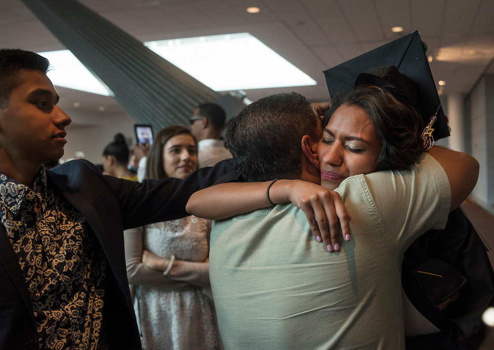 Maria Duarte, a DACA recipient, embraces her father while her brother David , left, age16, watches following Chatham University's graduation at the David L. Lawrence Convention Center. Duarte is the first person in her family to graduate from college. She received a BA in psychology.
