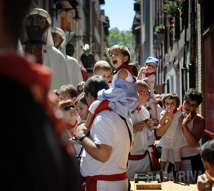 Parents and children attend the Gigantes and Cabezudos (giant and large head puppets) parade, in a street of the the Northern Spanish city of Pamplona during the San Fermin festival, on July 12, 2012. PHOTO / Rafa Rivas