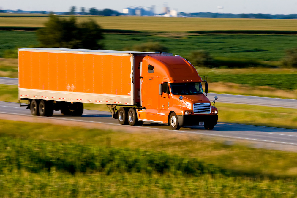 An orange truck and trailer is speeding across the Illinois prairie on I-57 near Gilman, IL.