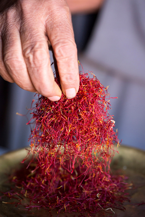 TALIOUINE, MOROCCO - October 26th 2015 - Saffron trader weighs saffron for a customer at his market stall in the Taliouine market, Souss Massa Draa, Morocco