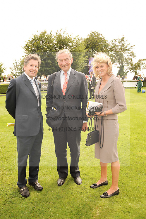 Left to right, JOHN WARREN the Queen's racing manager and LUCA & SARA CUMANI at the third day of the 2010 Glorious Goodwood racing festival at Goodwood Racecourse, Chichester, West Sussex on 29th July 2010.
